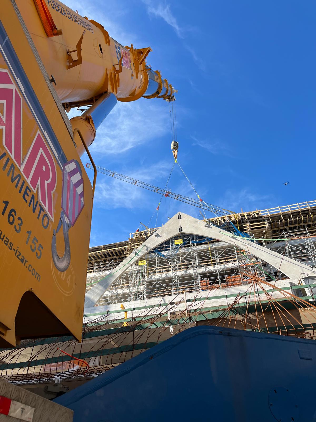 Grúa IZAR izando una pieza prefabricada de hormigón en obra